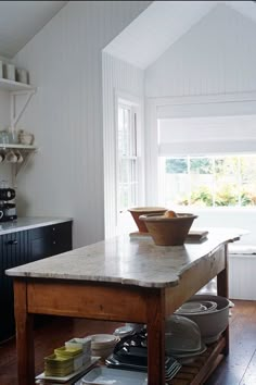 a kitchen island with bowls and plates on it