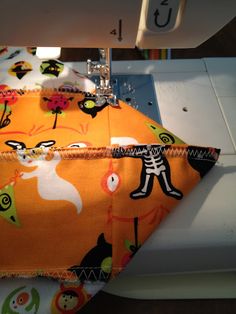 the sewing machine is next to an orange fabric with black and white images on it