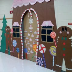 a large gingerbread house decorated with candy canes and candies on the door