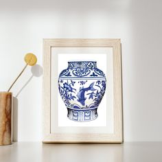 a blue and white vase sitting on top of a table next to a wooden container