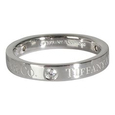 a white gold ring with diamonds on the inside and outside, engraved in two different languages