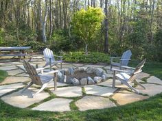 an outdoor fire pit with chairs around it