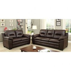 two brown leather sofas sitting next to each other