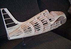 a model of a boat made out of wooden planks sitting on a black couch