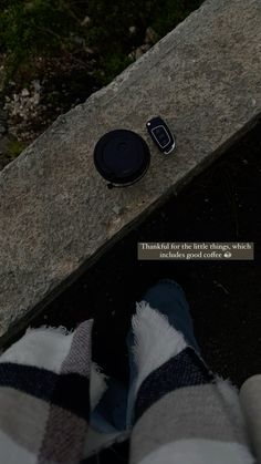 a cell phone laying on the ground next to someone's feet