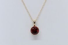 Adorn yourself with our Garnet Birthstone Pendant - a rich 5mm garnet gem set in the warmth of 10k yellow gold, symbolizing January's birthstone. Garnet is revered for its associations with strength, protection, and warmth. Elevate your style with the deep red hues of this gem, capturing the essence of your birth month. Classic Round Cut Birthstone Gemstones, Classic Gemstone Birthstone Necklace For Anniversary, Classic Birthstone Necklace For Anniversary, Formal 14k Gold Birthstone Gemstones, Classic Yellow Gold Birthstone Gemstones, Classic Birthstone Necklace For Formal Occasions, Red Birthstone Necklace, 14k Gold Birthstone Necklace For Formal Occasions, Classic 14k Gold Birthstone Necklace