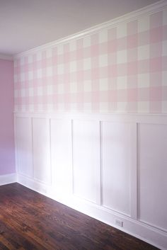 empty room with pink and white wallpaper in the corner, wood flooring on the other side