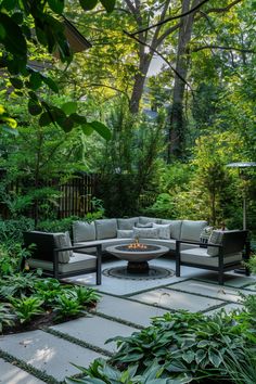 an outdoor fire pit surrounded by greenery