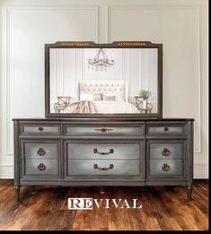 a dresser with a mirror on top of it and a chandelier in the background