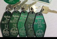 four green key tags with the names of hotels and other places on them are shown