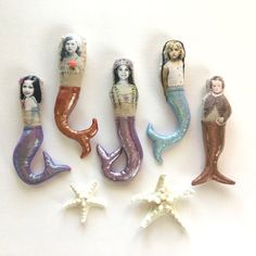 five little mermaids are sitting in the shape of starfish and one is holding a doll