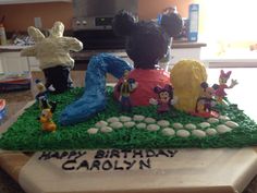 a birthday cake with mickey mouse figurines on it