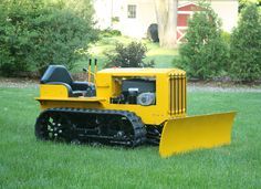 a yellow bulldozer sitting in the grass