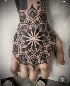 a person's hand with a black and white tattoo design on the left hand