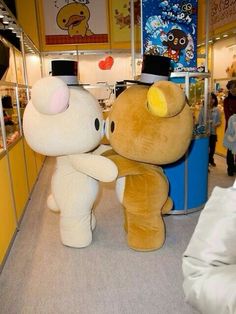 two large stuffed animals sitting next to each other in a room filled with children's toys