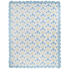 a blue and green flowered napkin on a white background with scalloped edges