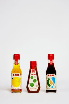 three bottles of sauce sitting next to each other