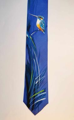 "\"The Kingfisher\" A bright blue silk tie with a hand painted Kingfisher with waves of long grass beneath the bird. This painting on silk is the perfect gift for bird admirers. All proceeds go towards a bird appreciation enthusiast. (Me) 100% pure silk 150cm Length 9cm Width across the blade Dry Cleanable Designed and individually hand painted by Jane Ireland. Over 20 years of experience in designing and painting silks to order. Jane's work is sold worldwide and she can be met in person at Cove Blue Tie For Summer As A Gift, Blue Ties For Summer Gift, Blue Tie For Summer Gift, Blue Ties As Summer Gift, Kingfisher Painting, Painting On Silk, Bird Watchers, Kingfisher, Silk Painting