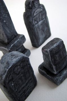 four black tombstones sitting on top of a white surface