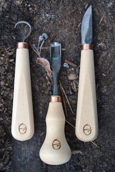 two knives and a pair of pliers on the ground next to each other with metal handles