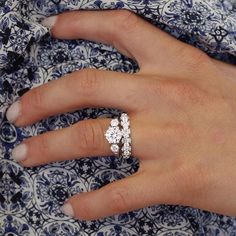 a woman's hand with two diamond rings on her left and the middle finger