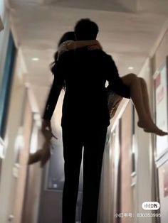 a man and woman are walking down the hallway