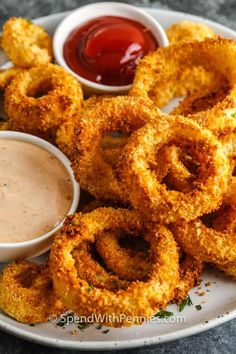 fried onion rings on a plate with dipping sauce