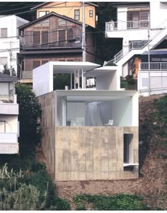 a house on the side of a hill with lots of windows and balconies