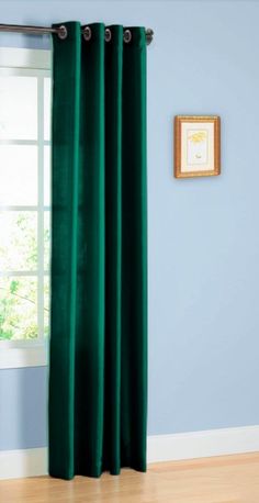 a green curtain hanging on the side of a blue wall next to a window in a room