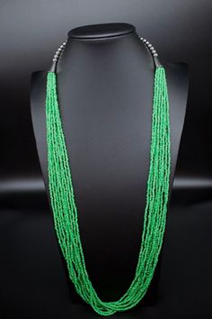 This is a multi strand green glass seed bead necklace. Southwestern glass green seed bead necklace. Dress it up or down. Great for the office.  *10 strands of glass seed beads *Adjustable length on this beauty up to 33". Has a lobster clasp. *Gift boxes available. All jewelry also comes in a nice box.  *Check out the rest of our collection: https://www.etsy.com/shop/NewMexicoGems Thank you for your business. We appreciate you. Multi-strand Green Large Beads, Bohemian Multi-strand Green Beads, Bohemian Green Multi-strand Beads, Green Multi-strand Beaded Necklaces With Large Beads, Green Multi-strand Beaded Necklace With Large Beads, Green Multi-strand Jewelry With Tiny Beads, Green Multi-strand Beaded Jewelry, Green Multi-strand Necklace With Tiny Beads, Traditional Green Faceted Beaded Necklaces