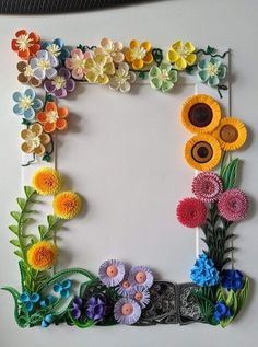 paper flowers are arranged in the shape of a frame