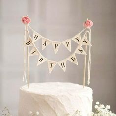 a white cake topped with a happy birthday banner