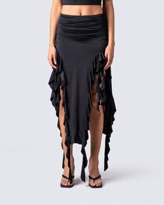 Owning an entire room has never been easier 😏 Rock your darker side with this sultry black jersey skirt. Complete with a high-waisted fit, shirring at the waist and hips, and front cutout detailing with a cascading ruffle hem 🖤 Black Ruched Bottoms For Evening, Chic Black Draped Skirt With Ruched Detail, Chic Black Ruched Draped Skirt, Ruched Skirt Bottoms For Evening, Black Ruched Draped Skirt For Evening, Ruched Flowy Skirt For Party, Black Stretch Elastane Maxi Skirt, Black Elastane Bottoms For Club, Ruched Asymmetrical Skirt For Night Out