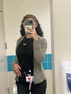 a woman taking a selfie in front of a bathroom mirror with her cell phone