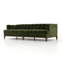 a green velvet couch with wooden legs on an isolated white background for use in interior design