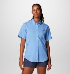 a woman wearing a blue shirt and shorts