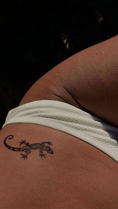 a lizard tattoo on the back of a woman's stomach