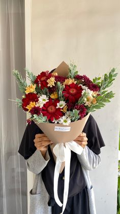 a woman holding a bouquet of flowers in her hands