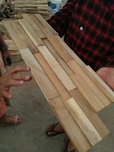 two people standing next to each other holding wooden planks