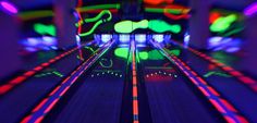 a bowling alley with neon lights and the words glow in the dark bowling on it