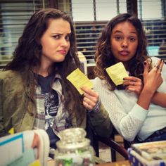 two women sitting at a table with sticky notes in their hands