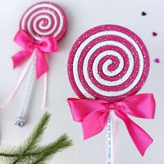 two candy lollipops with pink bows on them