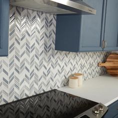 a kitchen with blue cabinets and white countertops has a wooden cutting board on the stove