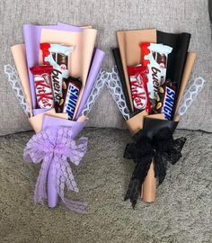 two candy bouquets sitting next to each other on top of a couch with lace