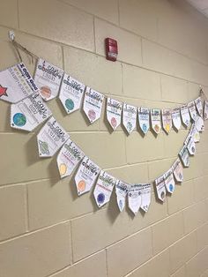 a bulletin board hanging on the wall in a school hallway decorated with magnets and papers