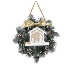 a christmas wreath with a nativity scene hanging from it