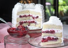 two pieces of cake with berries on the top and one slice is missing from it