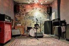 a room filled with lots of musical instruments and amps on top of a rug