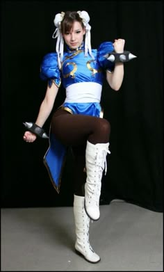 a woman dressed in blue and white is posing for the camera while holding two swords