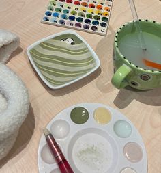 there is a bowl and paintbrush on the table next to some other items that are being used for painting